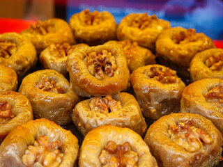 A close up of walnut topped baklava a traditional sweet dessert made with layers of flaky phyllo dough and sweet syrup
