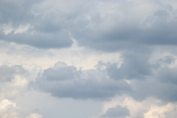 Fototapeta premium Overcast sky with thick gray clouds stretching across the horizon, creating a calm yet moody atmosphere above a distant landscape.