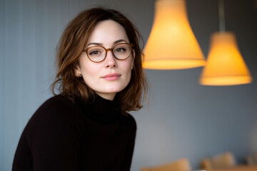 woman with glasses radiating intelligence is deeply engrossed in reading book at cozy caf