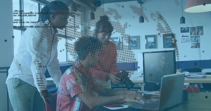 Collaborating three colleagues reviewing data on laptop at office desk, with DSLR camera and cables
