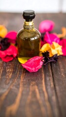 Perfume bottle surrounded by colorful flower petals on a dark wooden surface