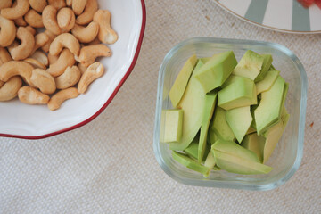 Fresh avocado slices and cashews served in a bowl