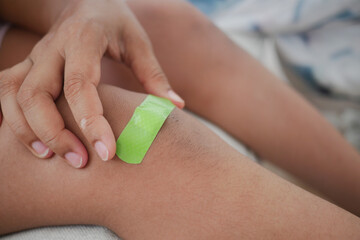 Applying a bandage to a child knee injury at home