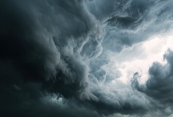 Obraz premium Dramatic shot of dark, swirling storm clouds, showcasing a turbulent sky with varying shades of gray and a bright opening in the center