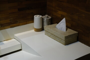 Woven tissue box and toothbrush holder on bathroom sink
