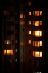 A quiet night view of an apartment complex Soft lights glow from kitchen windows The mood feels warm and restful, Generative AI