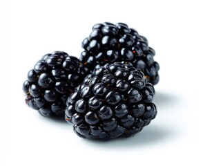 Three glossy blackberries clustered on a bright white background, showing deep, rich colors and textured surfaces