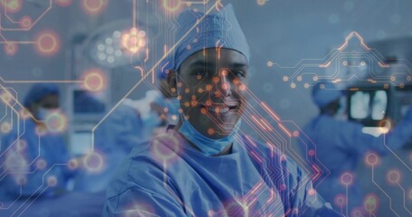 Performing surgery surgeon in blue scrubs monitoring operating table and digital overlay at OR