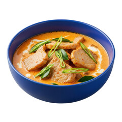 Vibrant panang curry with tender pork and kaffir lime leaves in a deep blue ceramic bowl, isolated on transparent, soft studio light, concept of culinary excellence