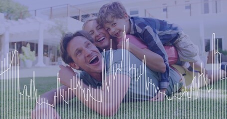 Laughing family stacking on grassy lawn in front of modern home, with pergola columns seating area