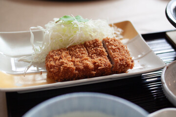 A beautifully presented Tonkatsu, a Japanese-style pork cutlet, coated in crunchy breadcrumbs and...