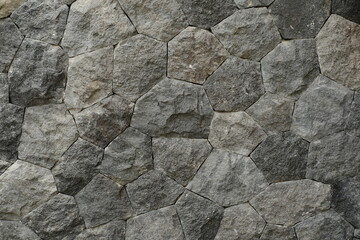 Gray natural stone wall with pentagon-shaped pattern background