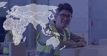 Smiling Korean man wearing safety vest leaning on box stack in warehouse, with world map overlay