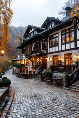 Obraz premium Charming hotel illuminating cobblestone street during autumn in the mountains