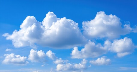 Fluffy white clouds drift across a vibrant, clear blue sky, creating a peaceful, airy atmosphere on a bright sunny day