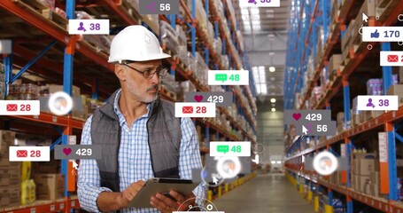 Supervisor inspecting inventory on tablet in warehouse aisle, with helmet, glasses, boxes and icons