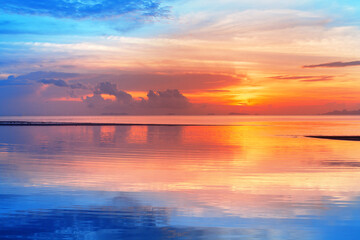 Sea beach sunset, calm ocean sunrise, beautiful peaceful tropical island landscape, idyllic seascape, colorful red orange yellow sky, golden sun reflection blue water, tranquil summer holidays, travel