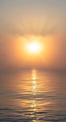 Fototapeta premium Serene sunrise paints the sky in warm hues, casting a golden path across tranquil ocean waters with gentle waves and distant birds soaring peacefully.