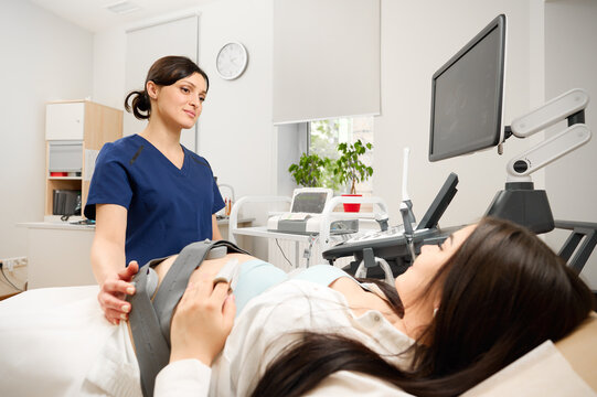 Pregnant woman undergoing cardiotocography procedure. CTG procedure to monitor fetal heartbeat and uterine contractions during pregnancy. A pregnant woman undergoes a medical examination.
