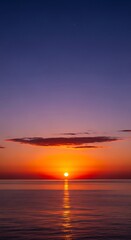 Fototapeta premium Spectacular sunrise over a calm sea with vibrant hues and clouds
