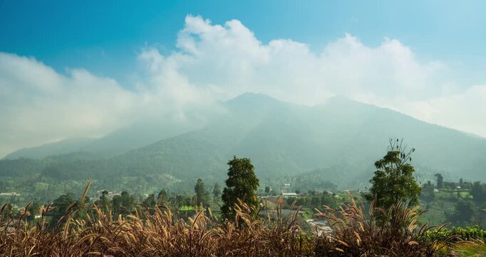Timelapse of clouds rolling over a mountain peak on a sunny day