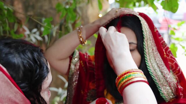 devotee performing sacred sindoor or vermilion rituals on chhath puja celebration