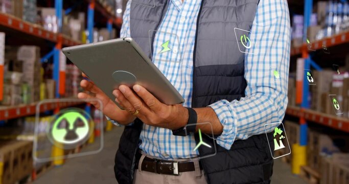 Business casual supervisor monitoring tablet in warehouse aisle with boxes, floating energy icons