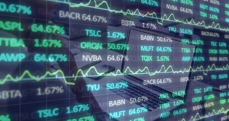Displaying open laptop showing stock data on desk, with smartphone notebook pen and coffee cup