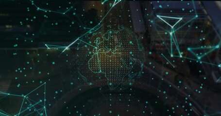 Hologram globe floating in workspace, with continent outlines in network mesh and blurry consoles