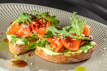 Bruschetta with smoked salmon, cream cheese, and fresh arugula on a plate