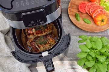 Meat cooked in a deep fryer. On the table are sliced ​​tomatoes and basil.