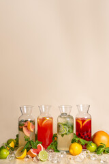 Refreshing assortment of lemonades in clear pitchers with ice cubes on peach background, perfect for menu design, cafes, and summer drink advertising.