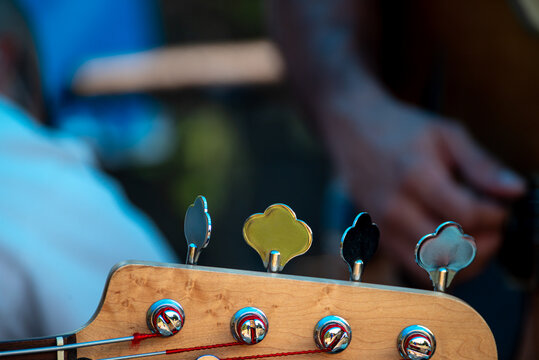 A close up of the headstock of a bass guitar with unique tuning pegs The Detail of a Custom Instrument - Powered by Adobe
