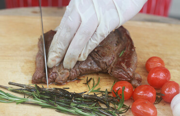The steak is being cut with a knife.