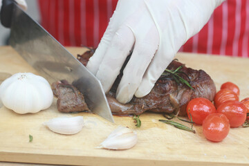 The steak is being cut with a knife.