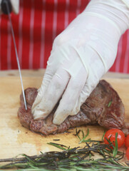 The steak is being cut with a knife.