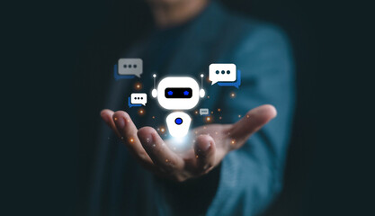 Artificial intelligence chatbot and virtual assistant concept with human hand holding glowing robot icon, digital communication, customer service automation, and futuristic technology.