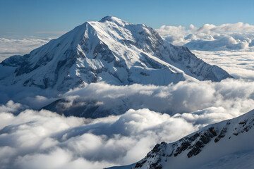Naklejka premium Majestic Snow Covered Mountain Peak Above White Clouds
