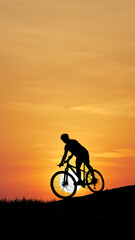 Silhouette Cyclist Against Sunrise: A solitary cyclist silhouetted against a radiant orange sky, embodies a spirit of adventure and determination.
