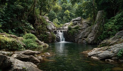 Lush waterfall cascading into tranquil pool, surrounded by rocks and dense jungle