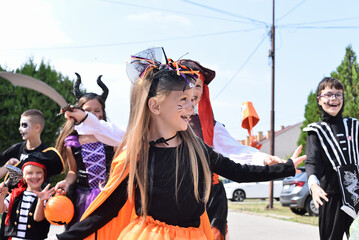 Children walking in the city picking up candy on Halloween