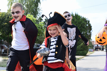 Children walking in the city picking up candy on Halloween