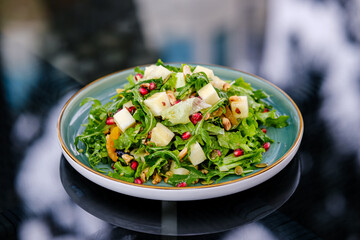 Plate of Fresh Vegetable Salad with Pomegranate Seeds and Cheese Cubes