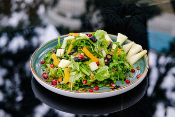 Plate of Fresh Vegetable Salad with Pomegranate Seeds and Cheese Cubes