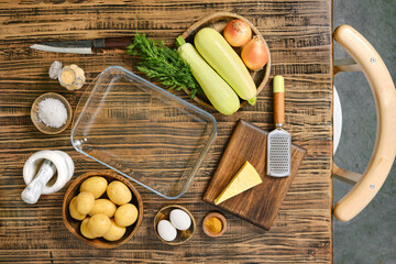 Loaded baked potato casserole preparation with fresh ingredients on a wooden table