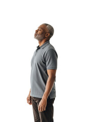 Elderly African man, salt-and-pepper hair, charcoal polo & dark chinos, eyes closed, head tilted, in a bright studio with transparent background, ample copy space, concept of serene introspection