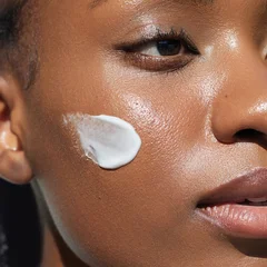 Natural Skin care beauty portrait. Cream smear. Hydration and oil balance. Nourishing and moisturising. African American young woman with  cosmetic product on her face © Beauty Agent Studio
