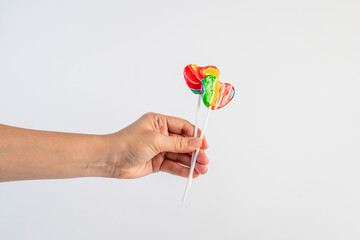 Sweets, two lollipops in hand, on white background