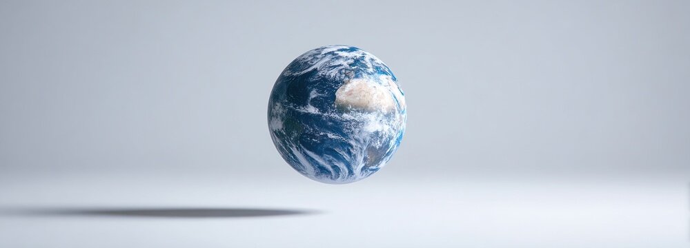 An Earth-textured egg shape hovers mid-air, casting a faint shadow on a light grey backdrop.  Details of landmasses and swirling clouds are visible