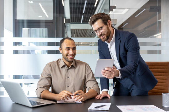 Business meeting, two managers discussing using tablet in office